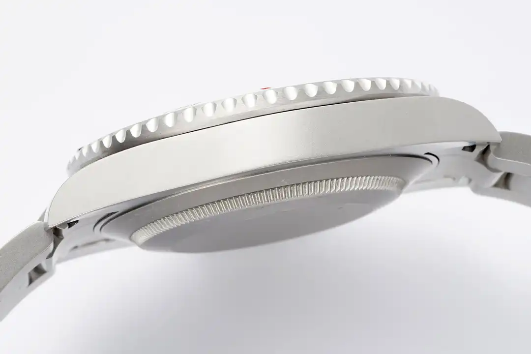 Case seen in profile from the far side, coin-edged rim above a knurled back