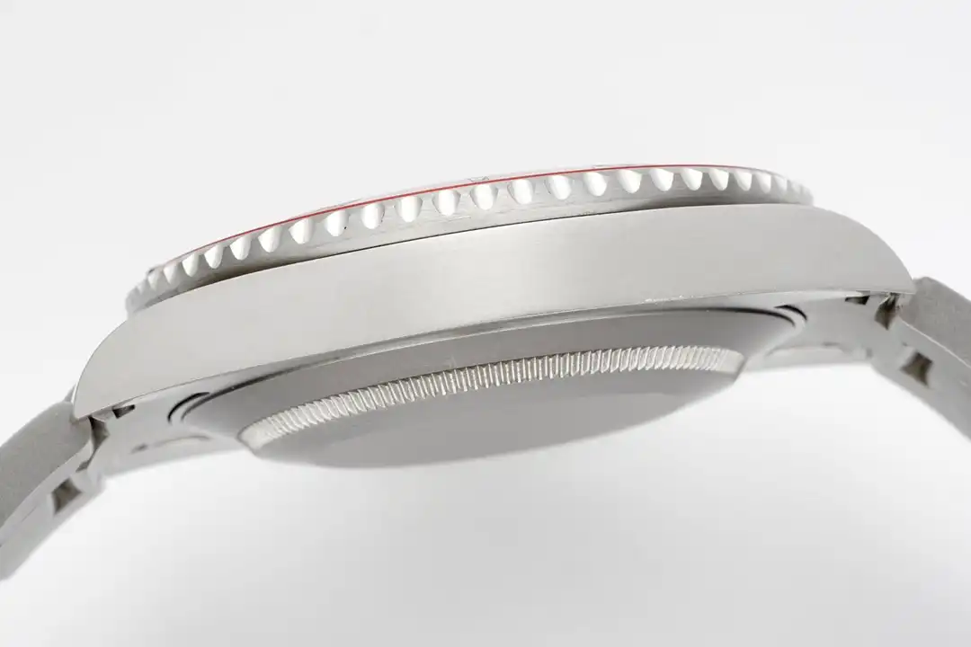 Profile of the case flank, coin-edge bezel teeth and a sliver of red insert