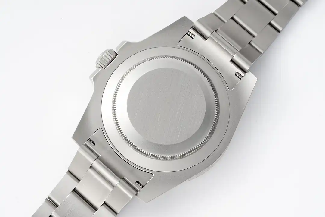 Caseback flat to the lens, plain brushed disc inside a fluted rim, nothing engraved