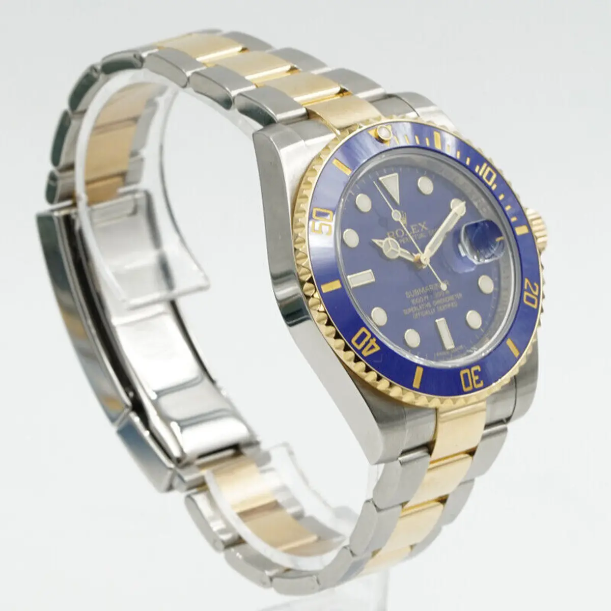 Angled three-quarter view on a clear stand, bracelet curved behind the case