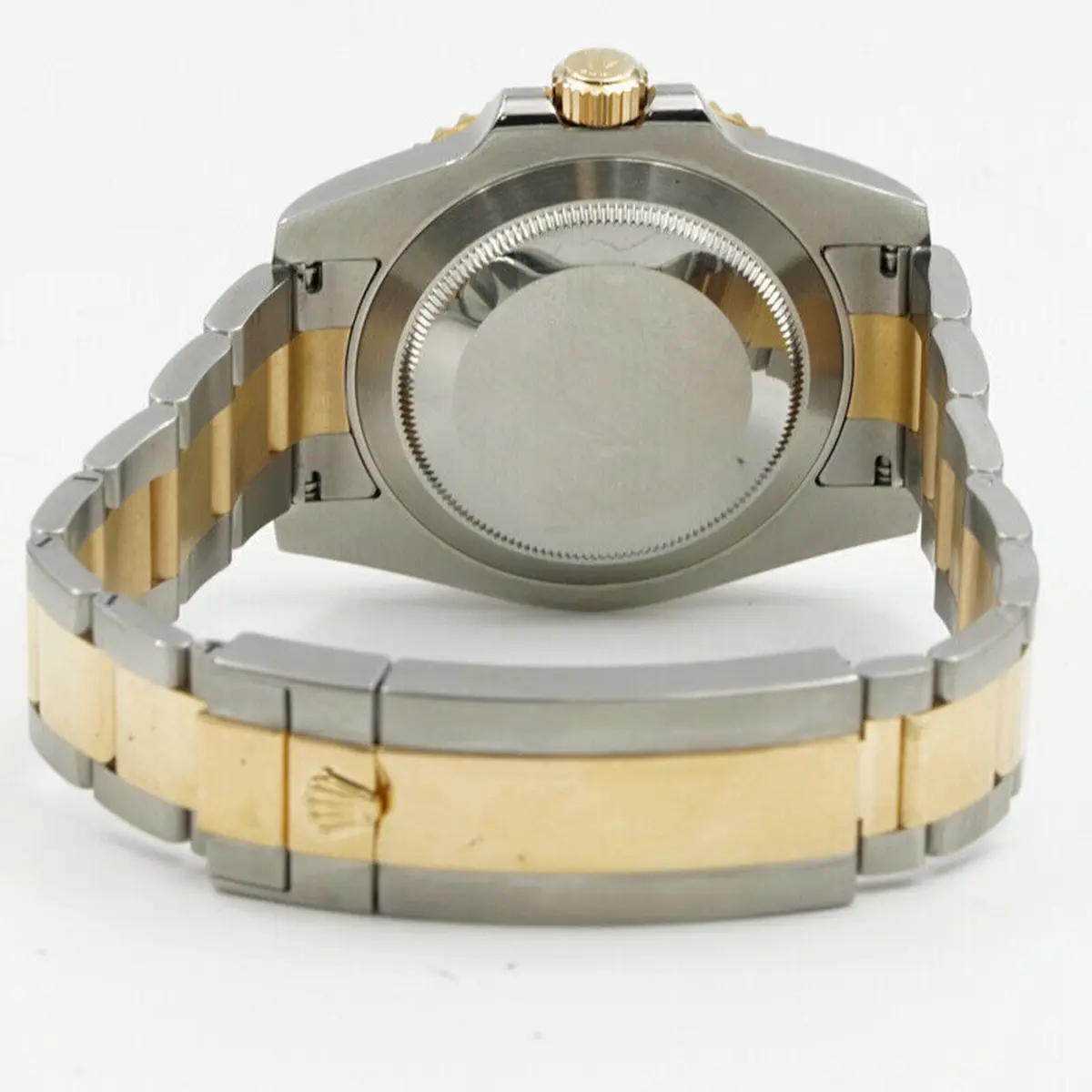 Caseback from behind, plain brushed disc, folding clasp with a coronet on the gold-tone cover