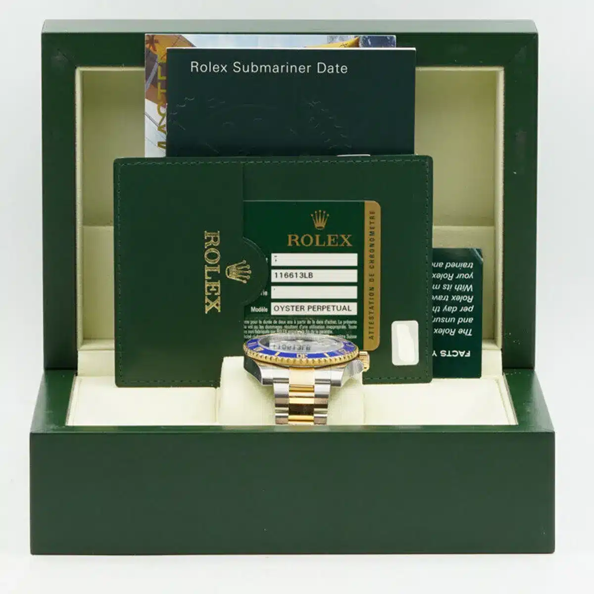 Watch resting in an open green presentation case beside booklets and a printed card