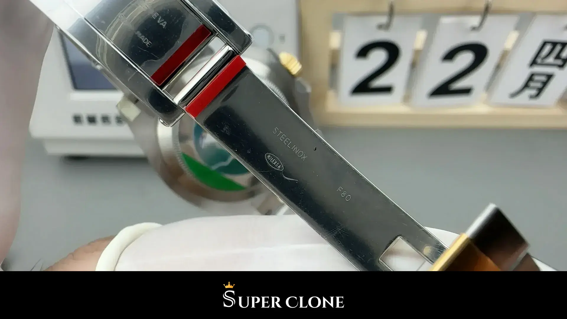 Clasp folded open, inner blade stamped with lettering and two red inlays