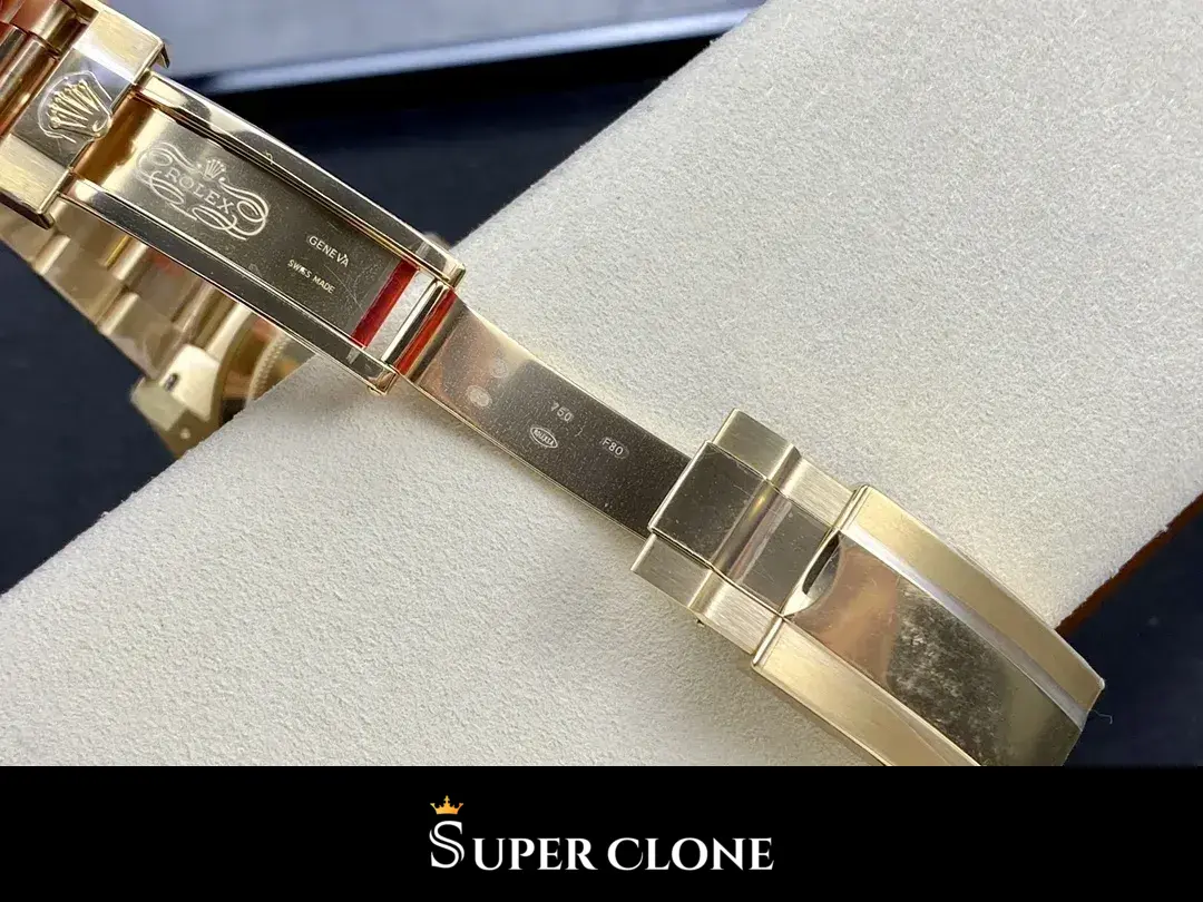 Clasp opened flat, folding blade and safety catch in polished gold tone