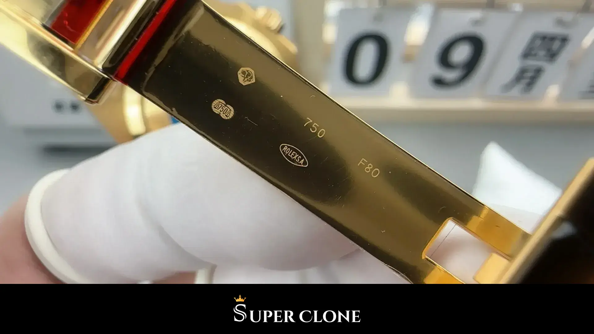 Clasp blade turned toward the light, polished gold-tone finish and folding catch