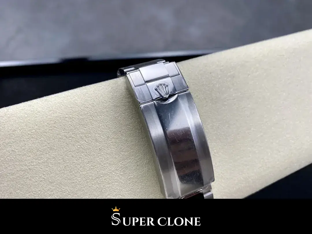 Folding Oyster clasp closed, coronet stamped on the cover, laid on a suede pillow